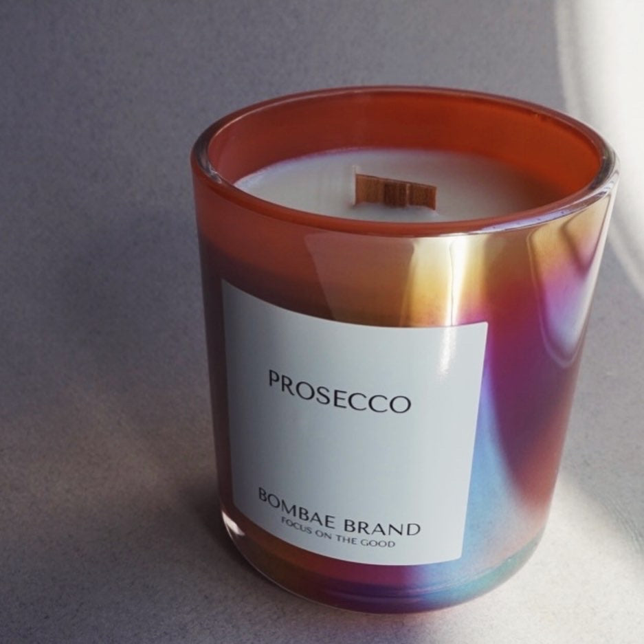 Hand-poured with 100% natural soy wax, our Prosecco candle fills your space with raspberry, sparkling wine & pink jasmine. Clean burning, cruelty-free & made for every celebration. Shop Bombae Brand.
